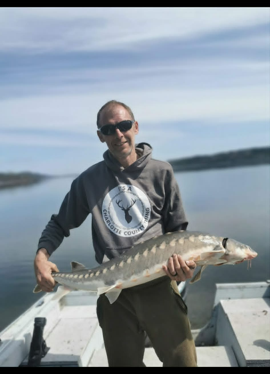 J Barrett holding a sturgeon on the boat