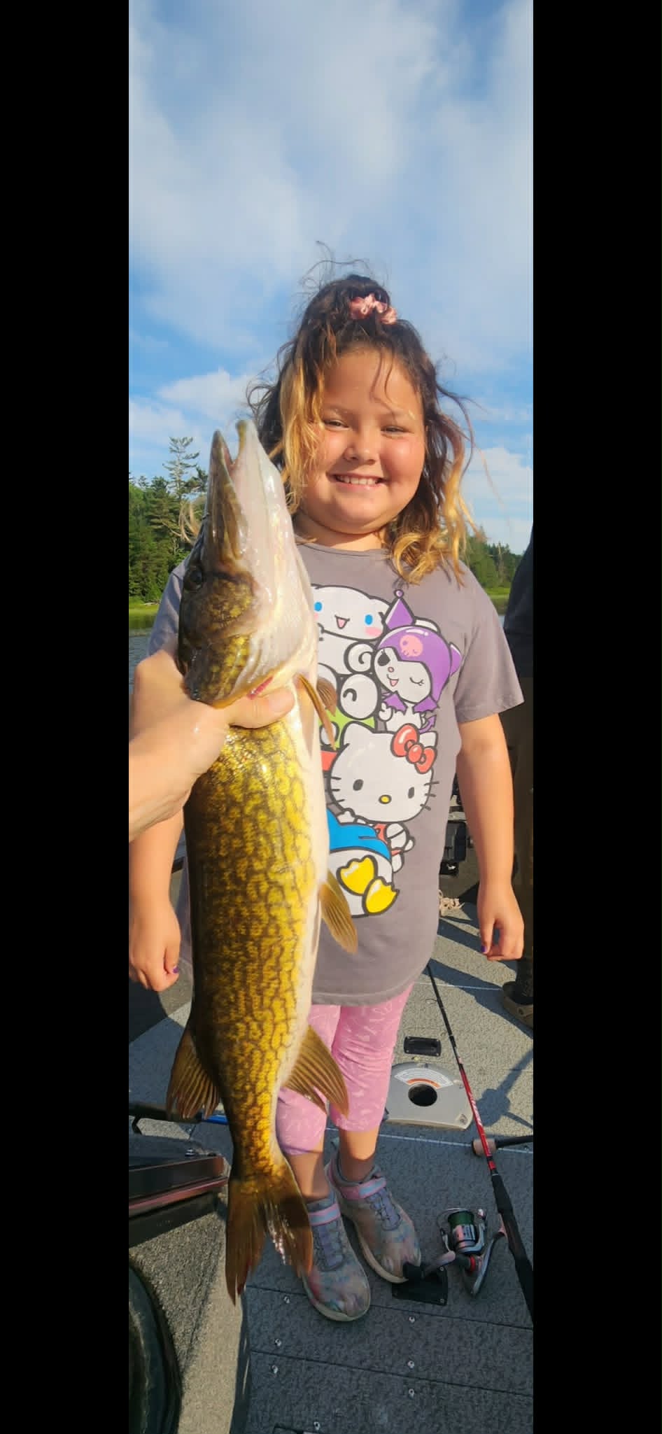 Young girl holding a pickerel on the dock