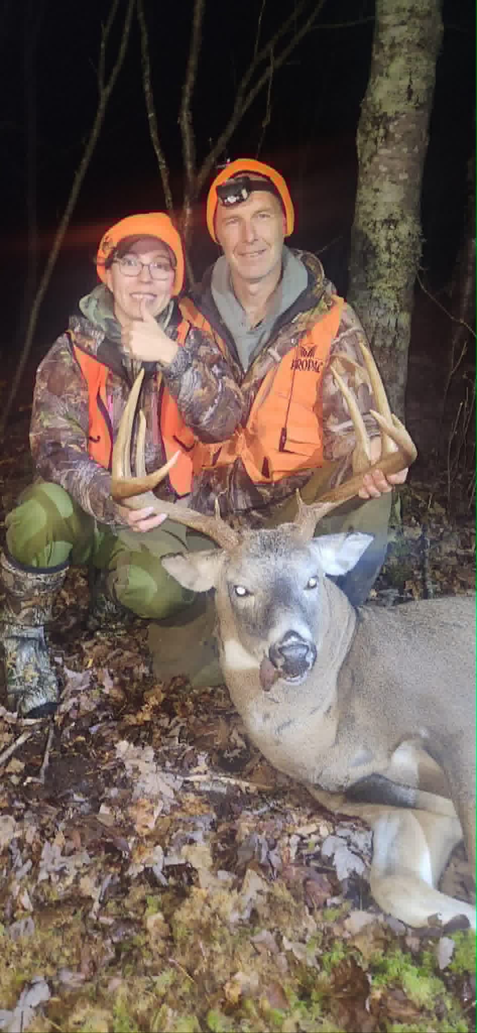 Hunters with a whitetail buck at night