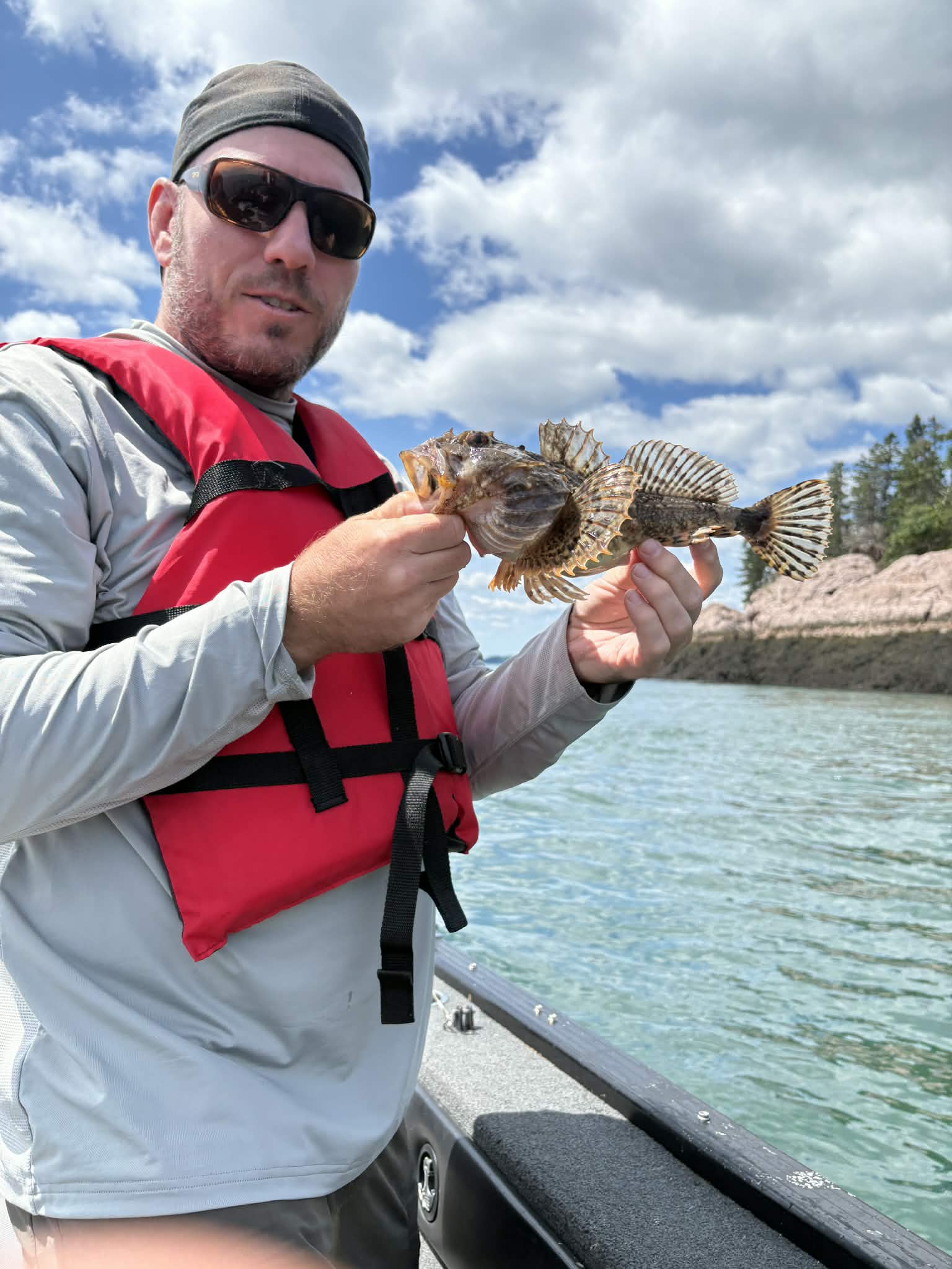 Angler holding a sculpin on a saltwater trip