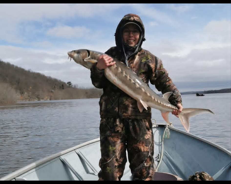 Angler holding a sturgeon on a cold spring morning