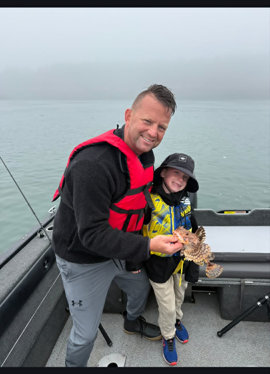 Father and son with a saltwater catch in the fog