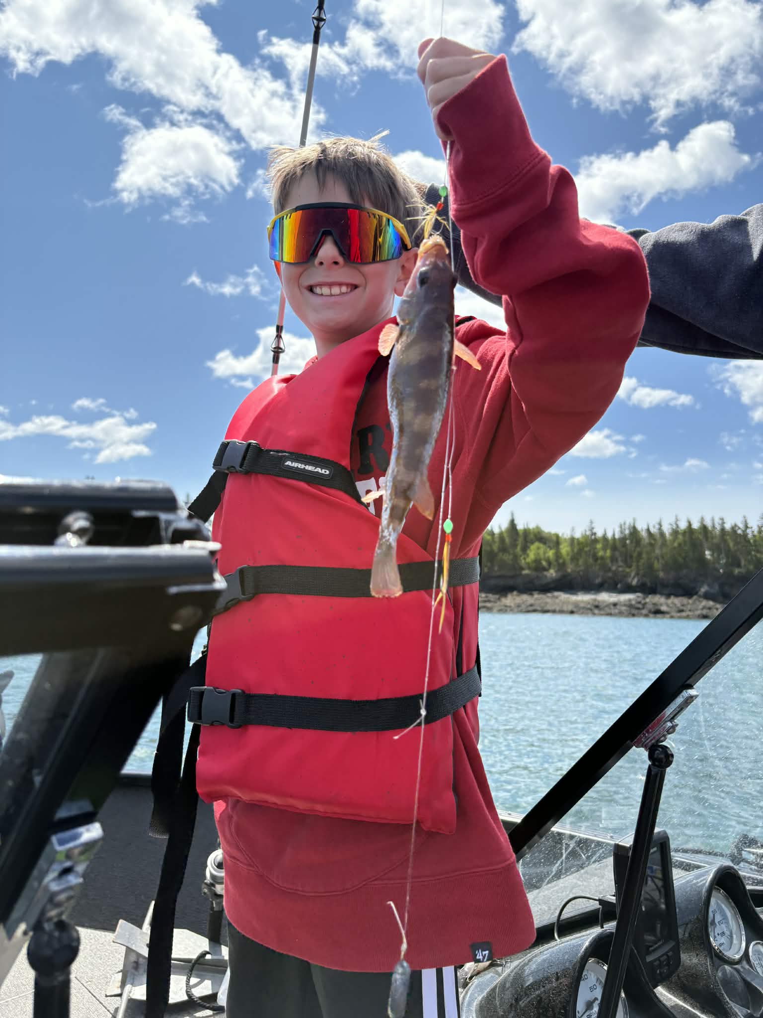 Young angler holding a small saltwater fish on the line