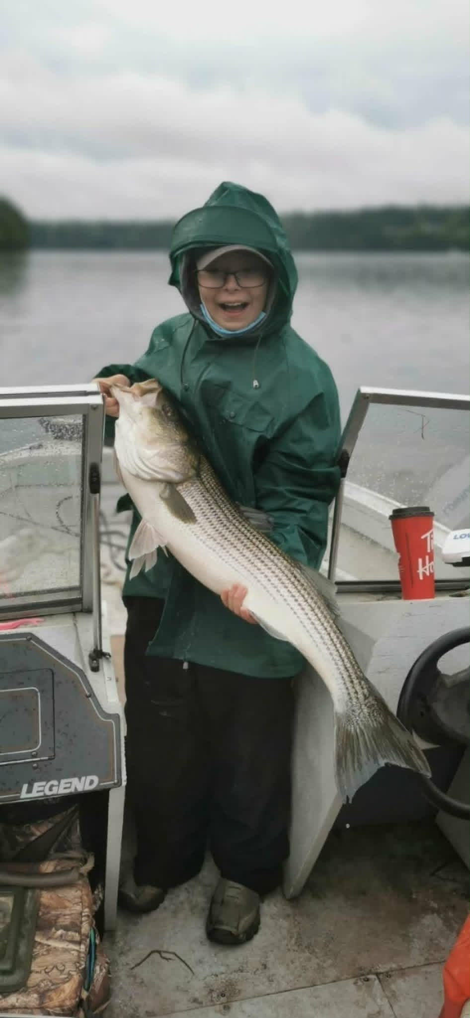 Young angler holding a striped bass on the Miramichi River
