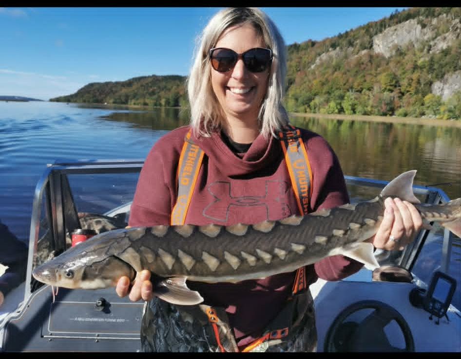 Angler holding a sturgeon on the boat