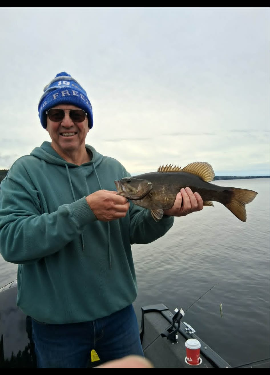 Angler holding a smallmouth bass on the lake