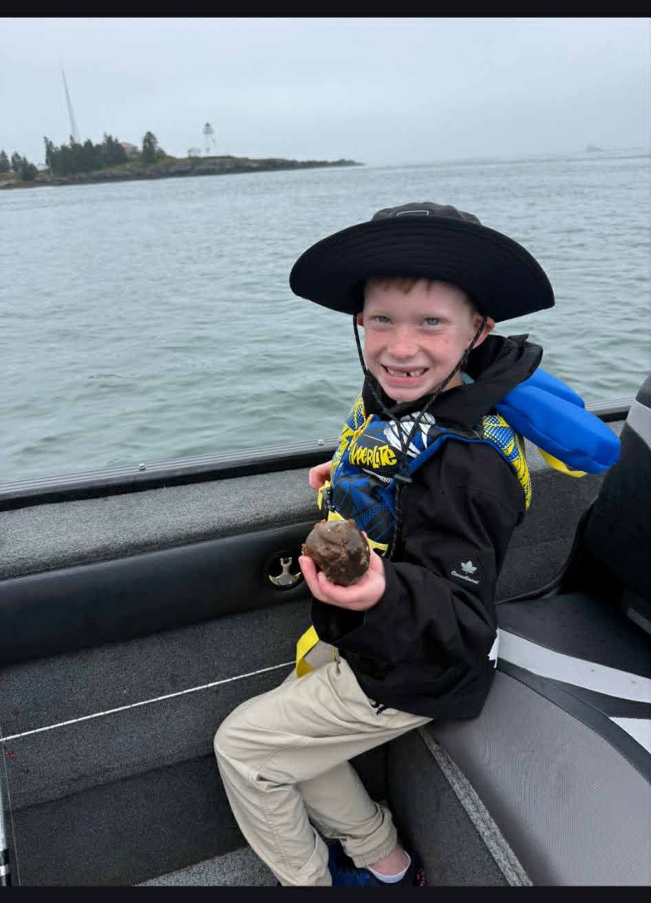 Young angler on a saltwater trip near a lighthouse
