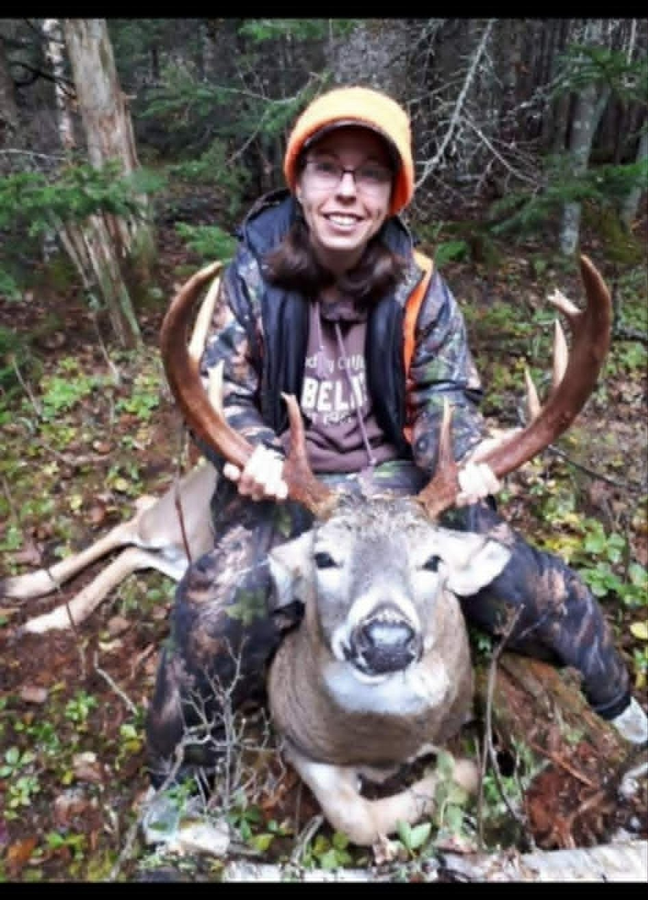 Hunter with a whitetail buck in the daylight